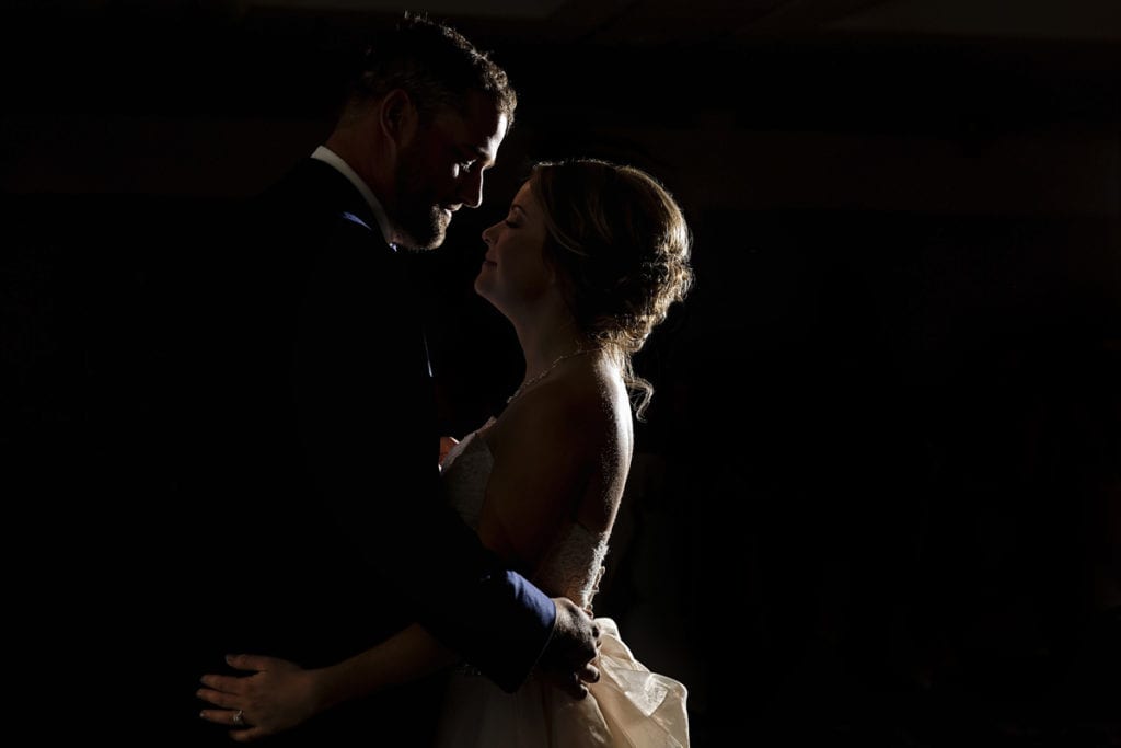 bride and groom in rim light during first dance at their Autumnal NAV Centre Cornwall Wedding