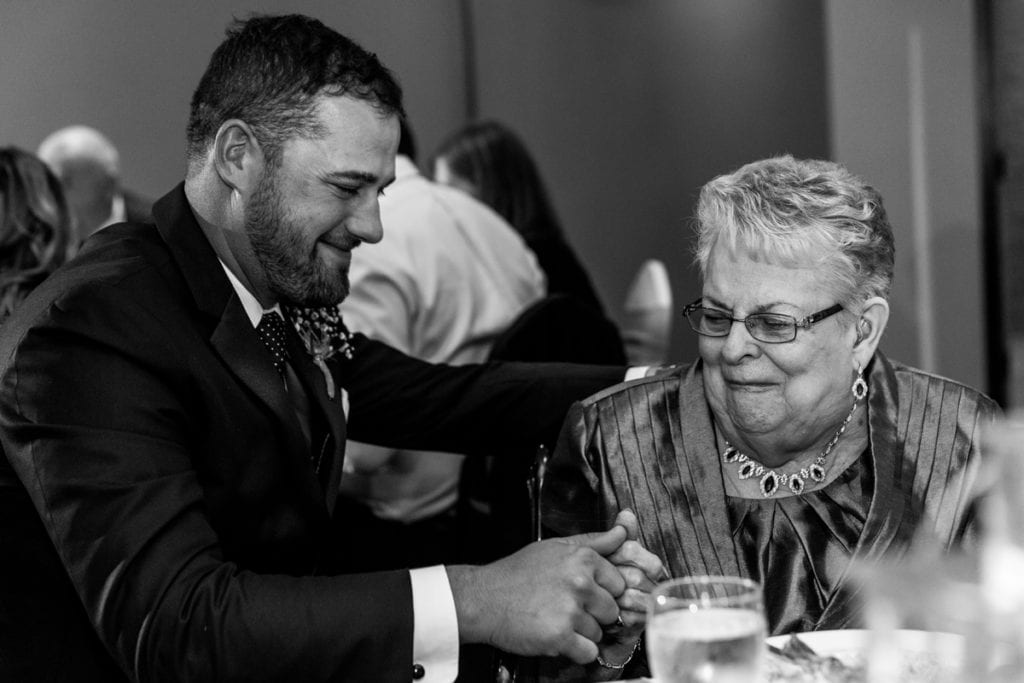 groom touching thumbs with grandmother during Autumnal NAV Centre Cornwall Wedding