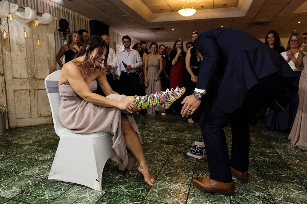 groom helping sister put on lighted socks during Autumnal NAV Centre Cornwall Wedding reception