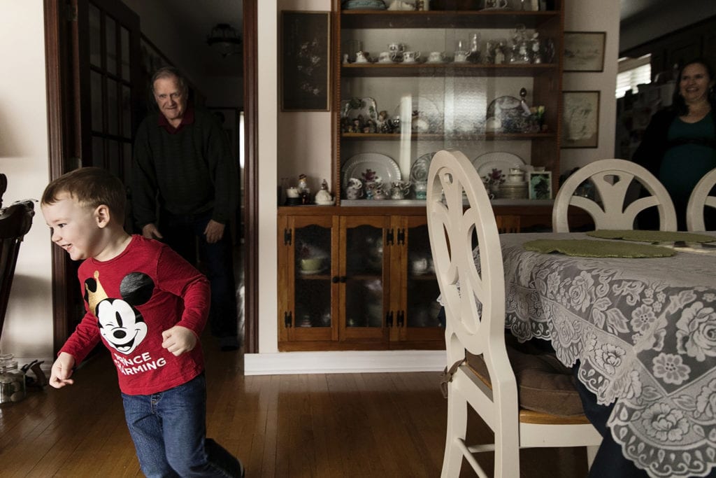 boy runs from grandpa during Ontario Family Photojournalism session