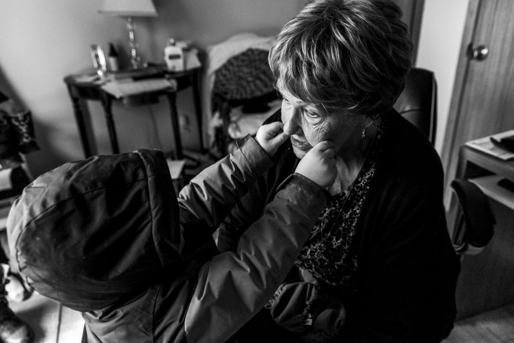 boy pinches grandma's cheeks during Ontario Family Photojournalism session