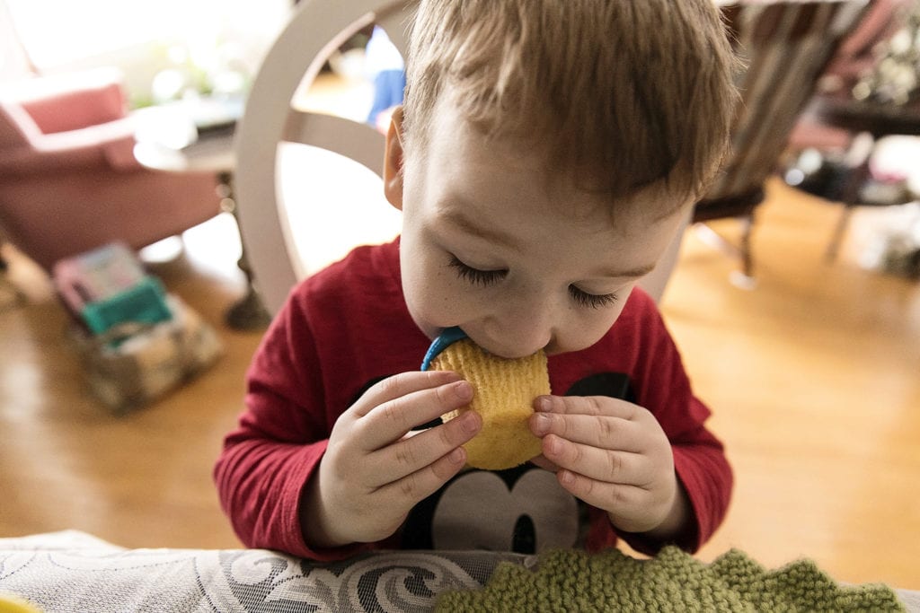 boy takes big bite out of cupcake during Ontario Family Photojournalism session