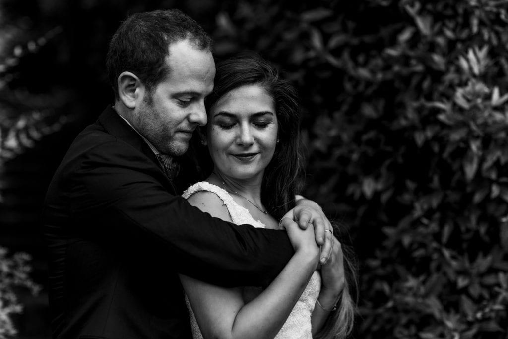 groom wraps arms around bride's shoulders
