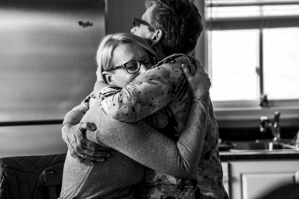 mother and daughter hug tightly during Eastern Ontario family photojournalism session