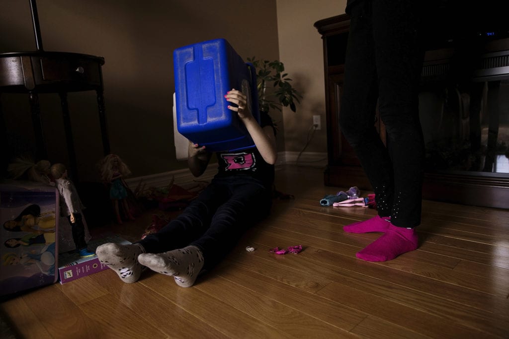 girl hiding head in blue cooler
