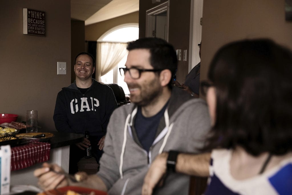 man laughing in background with family