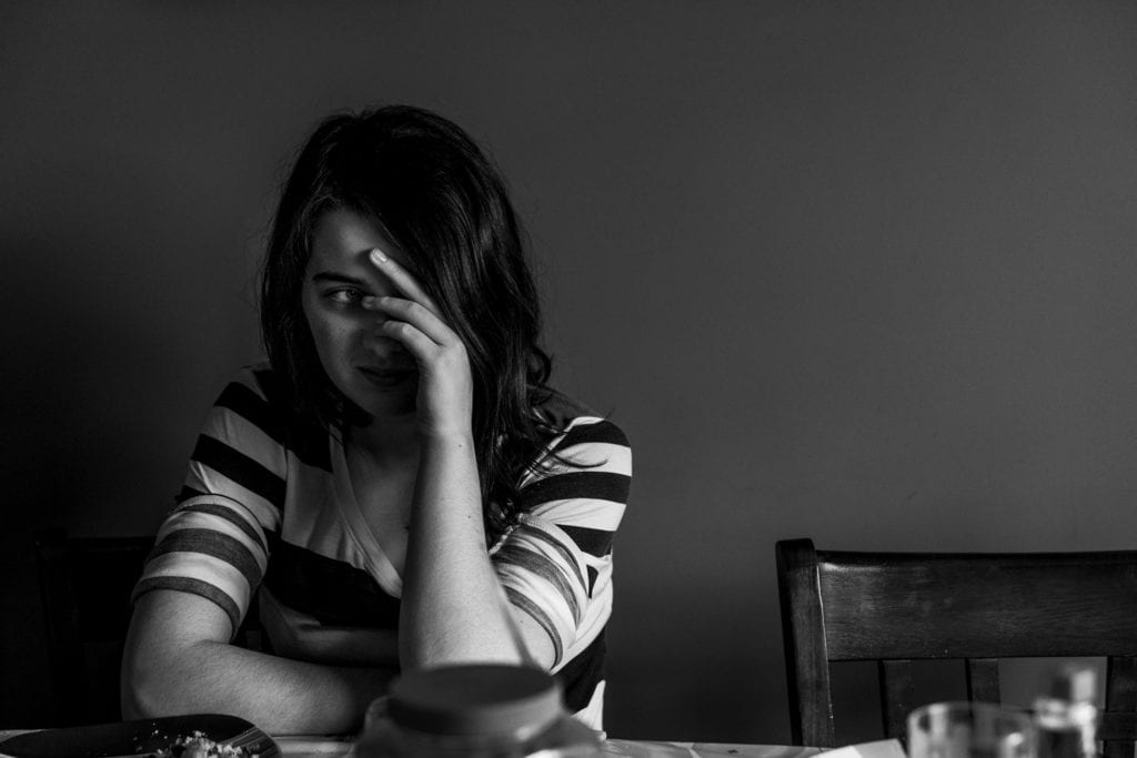 teenage girl looking through bangs with hair hanging in face