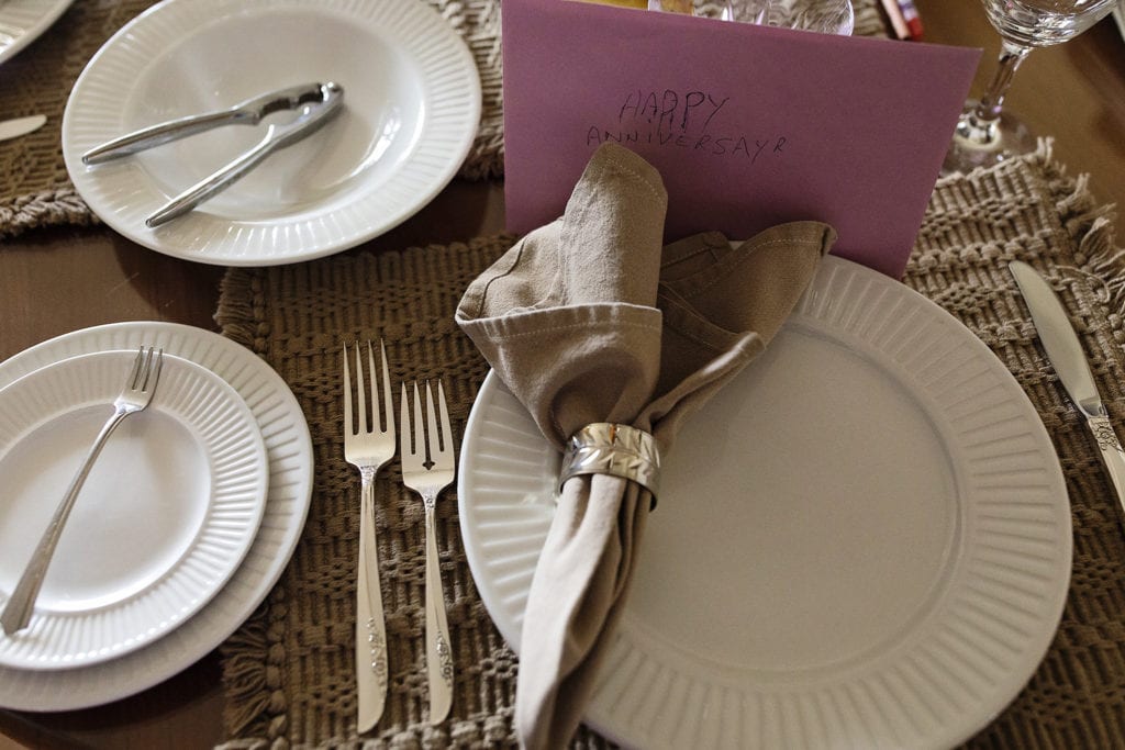 table laid with anniversary cards and fancy place settings for lobster dinner