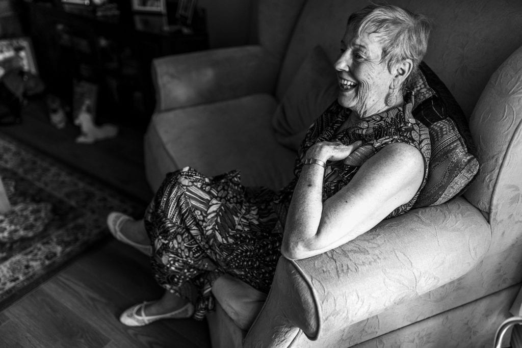 woman sits on couch and laughs