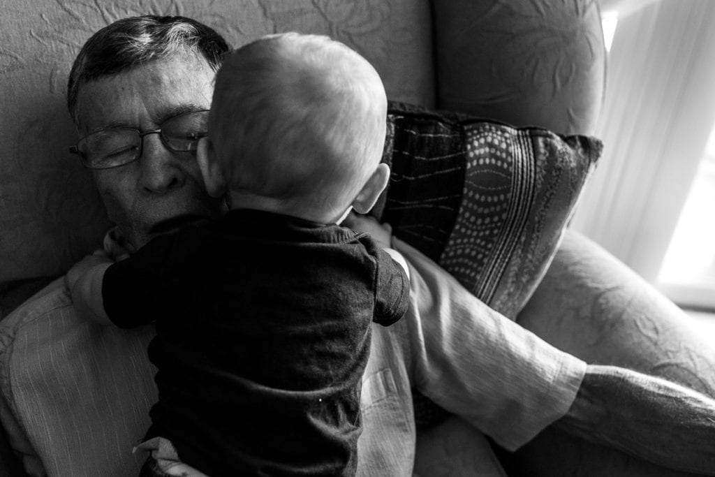 grandfather hugs grandson