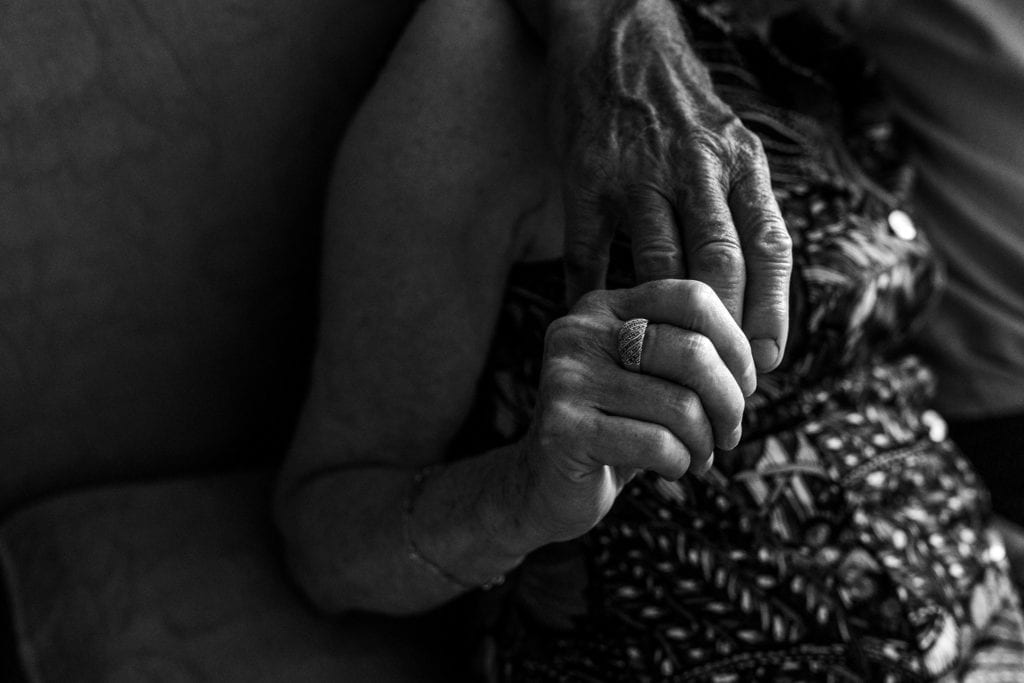 woman holds husband's hand