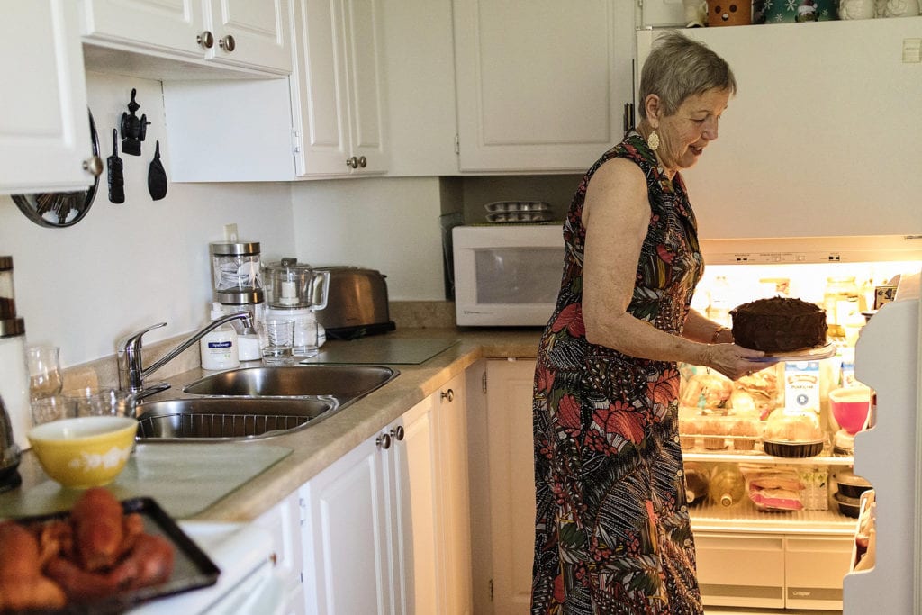 grandmother takes cake out of fridge