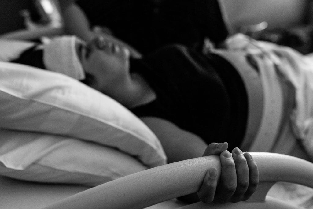 Mother labours through contractions while holding bedrail