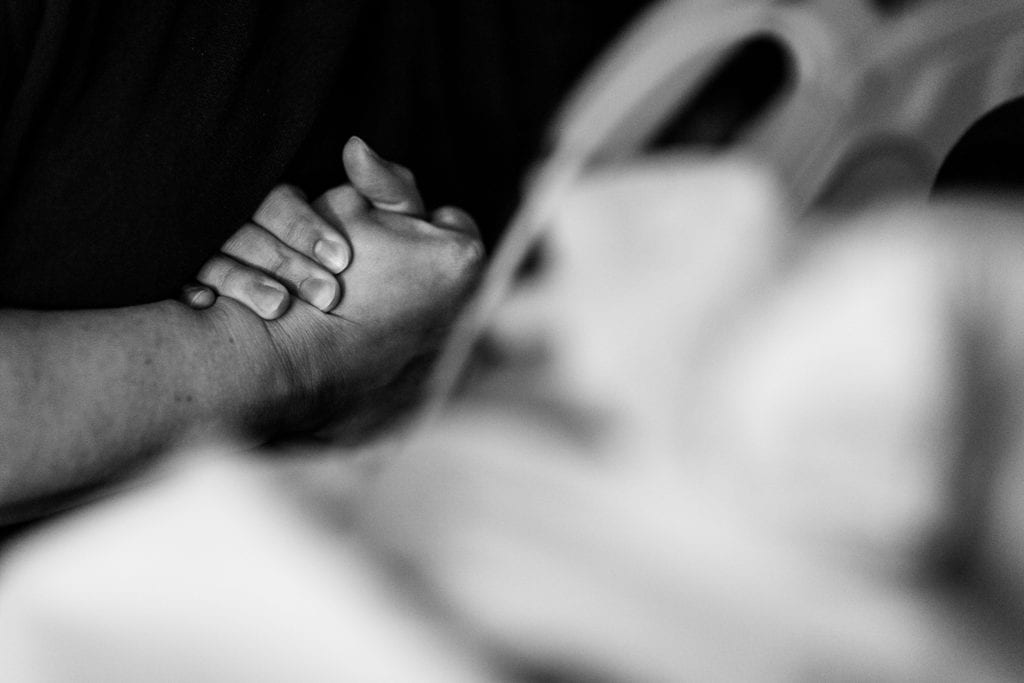 Women hold hands during labour