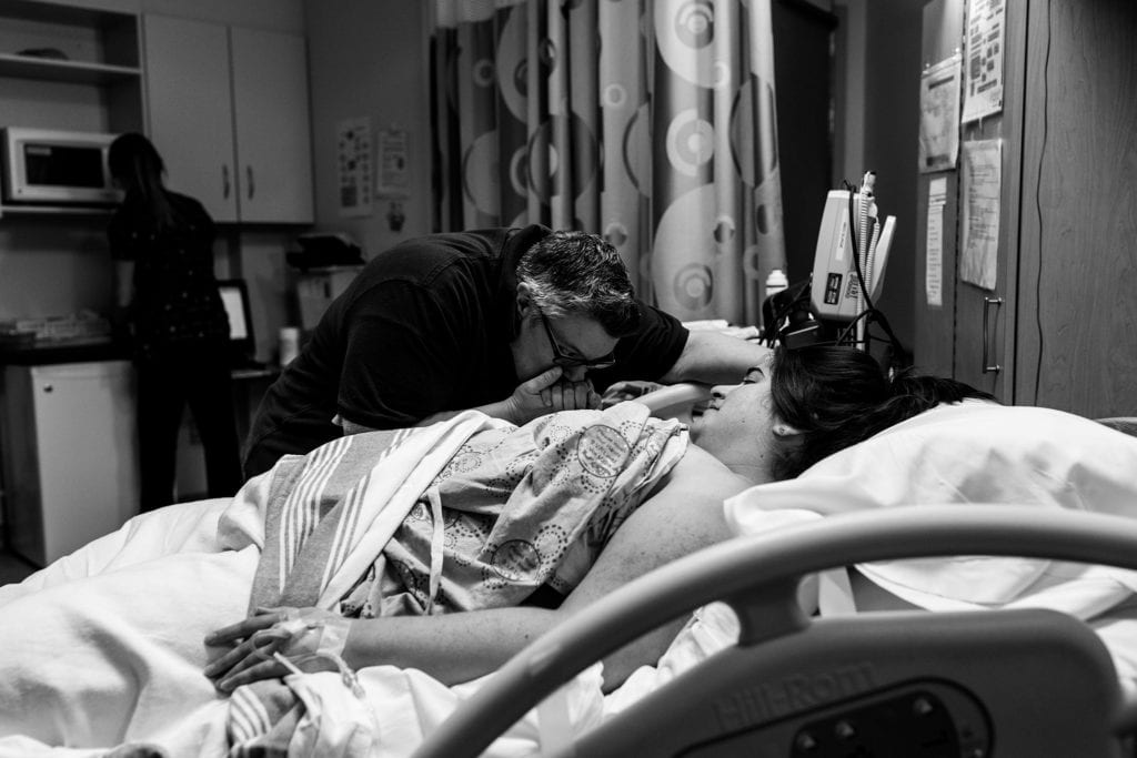 Woman kisses wife's hand between contractions