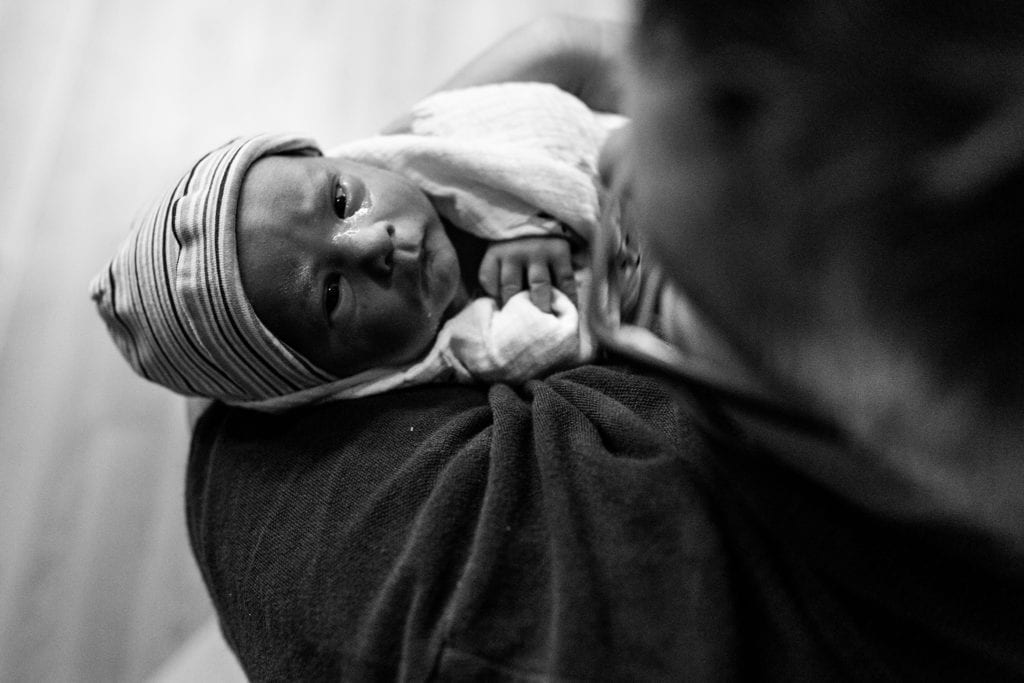 New baby looks up at mother