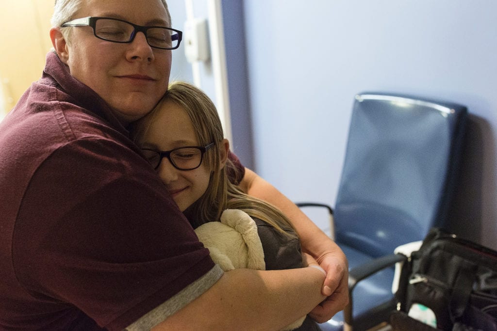 Mother and daughter hug after delivery of baby