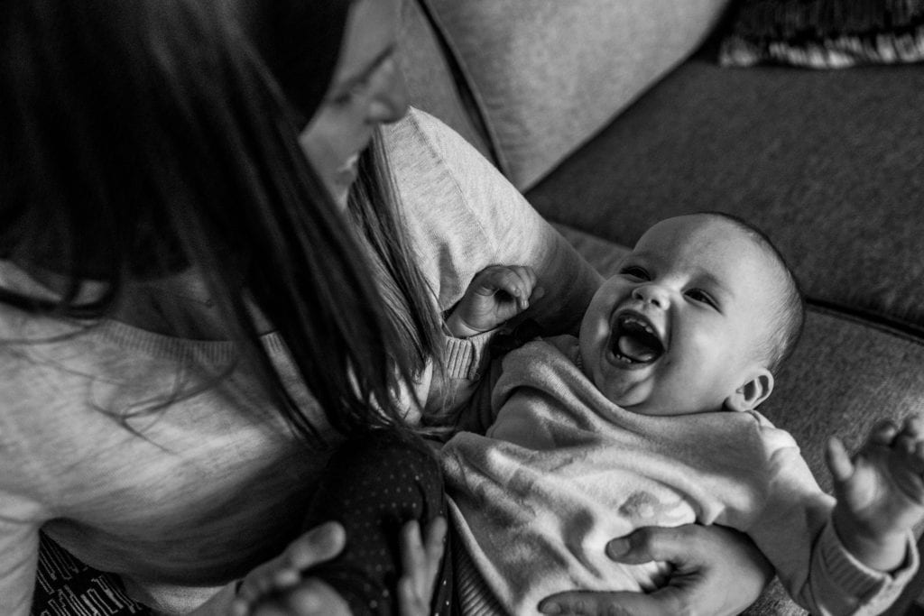 mom holds laughing daughter