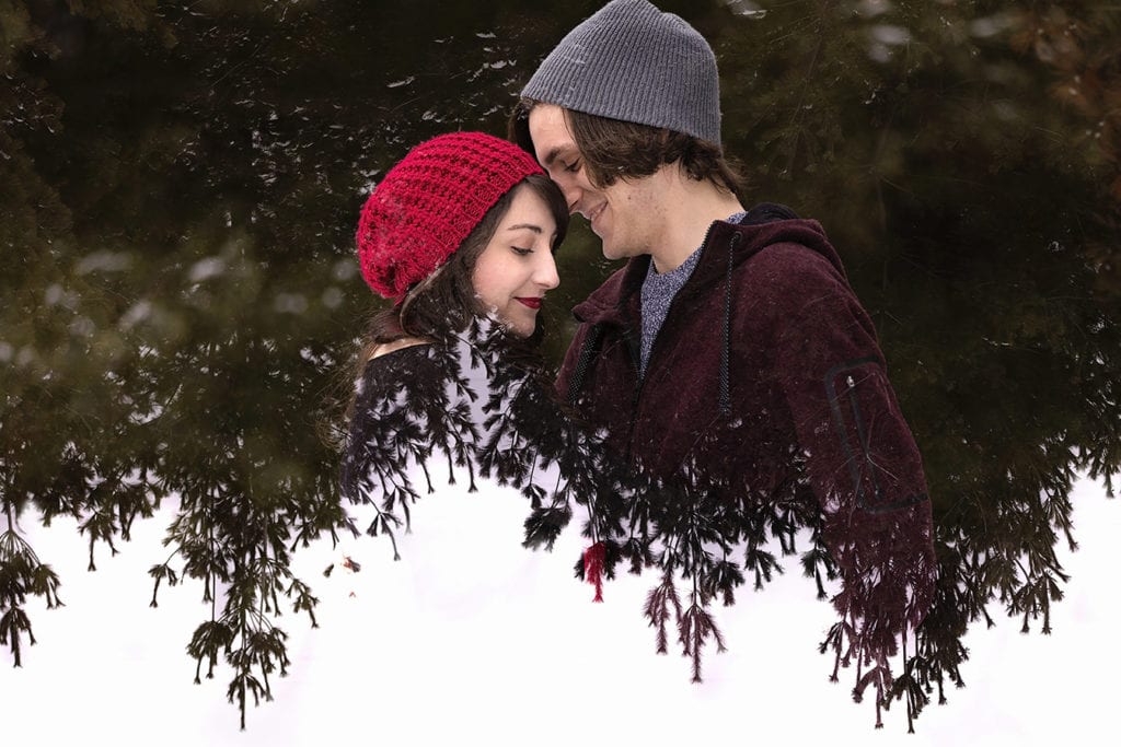 double exposure of pine forest and engaged couple in snowy winter engagement session