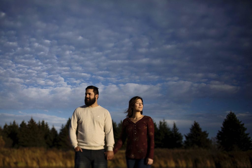 couple holding hands in fall field at sunset during Cornwall Autumn Engagement Session