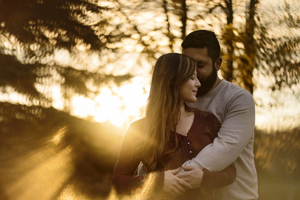 couple embracing against golden hour sun in Cornwall Autumn Engagement Session