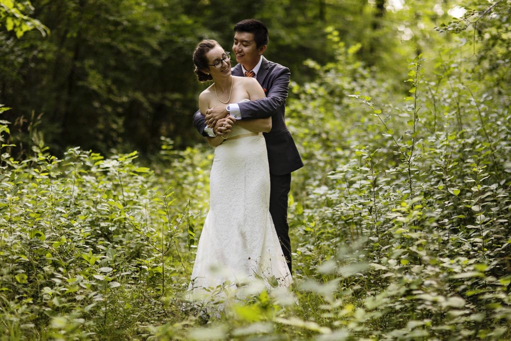 newly married couple embracing in summer greenery at intimate ottawa park wedding