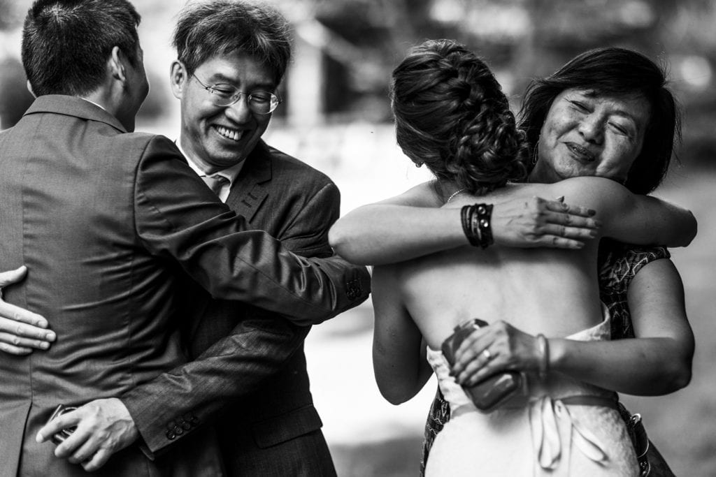 wedding guests hugging and congratulating bride and groom at intimate ottawa park wedding