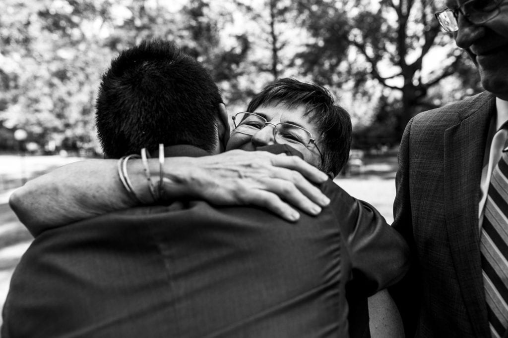 wedding guests hugging and congratulating groom after ceremony at intimate ottawa park wedding