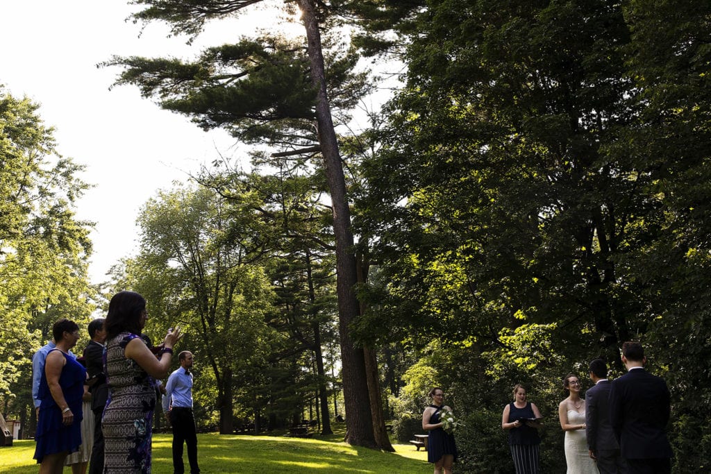 couple exchange wedding vows in forested green space during vincent massey park wedding
