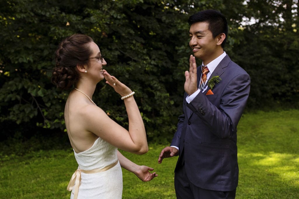 bride in lace mermaid dress high fives her groom during intimate ottawa park wedding