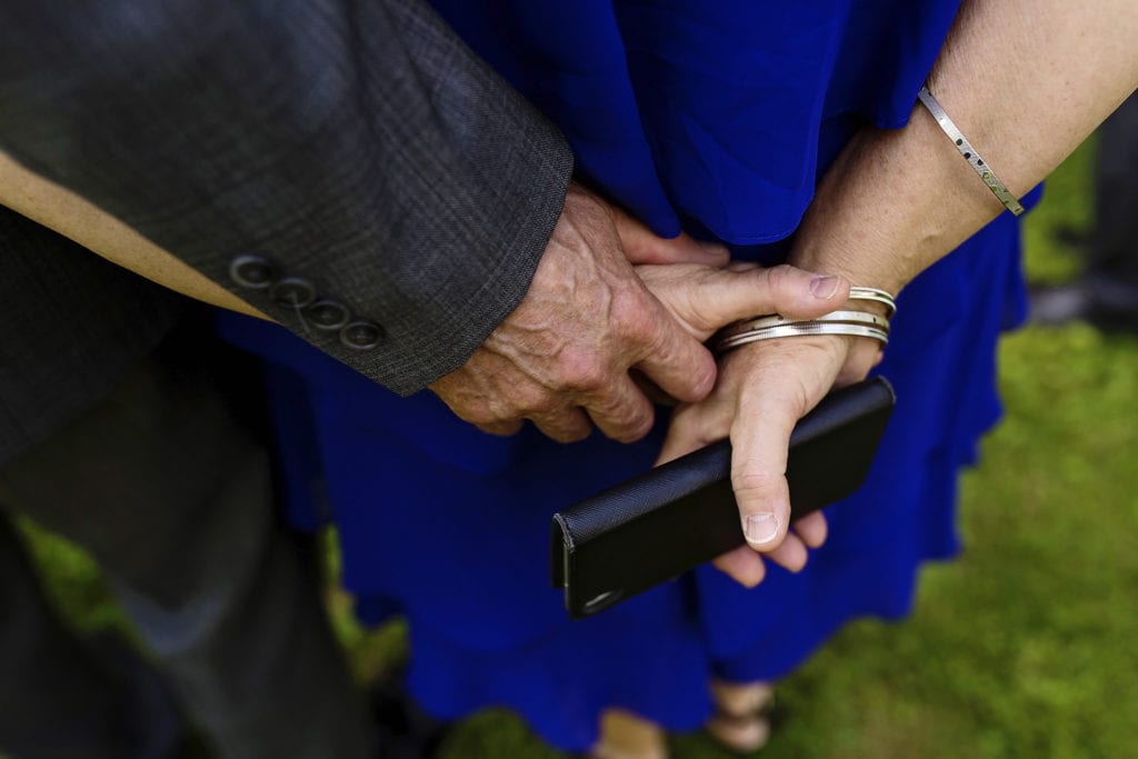 mother and father of the bride holding hands at intimate ottawa park wedding