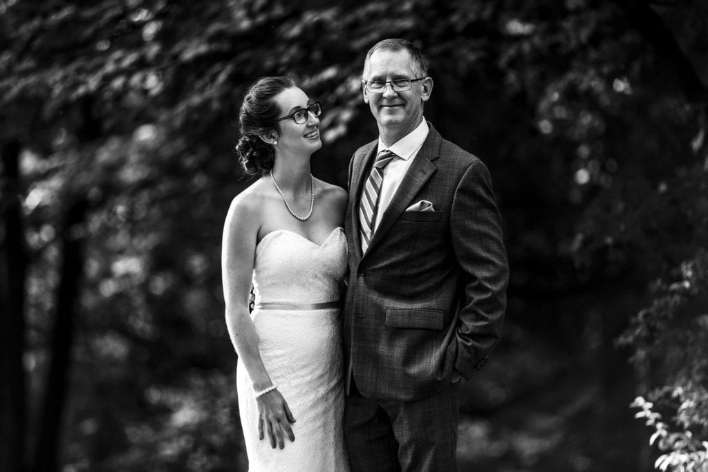 bride in glasseswith father of the bride against greenery in vincent massey park wedding