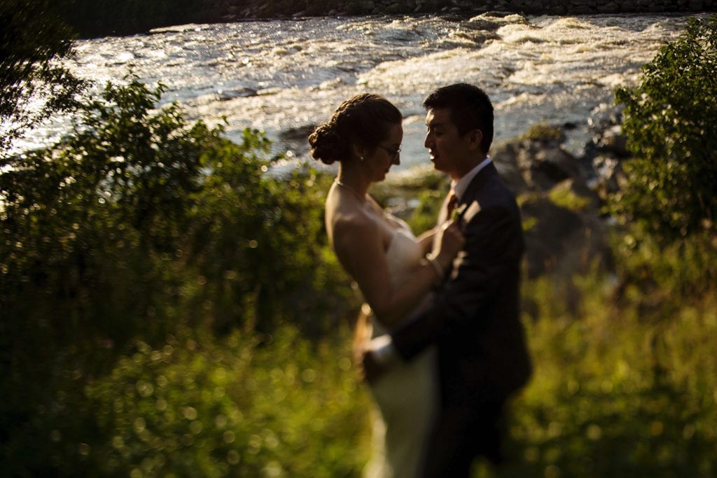 bride and groom standin on river's edge in intimate ottawa park wedding