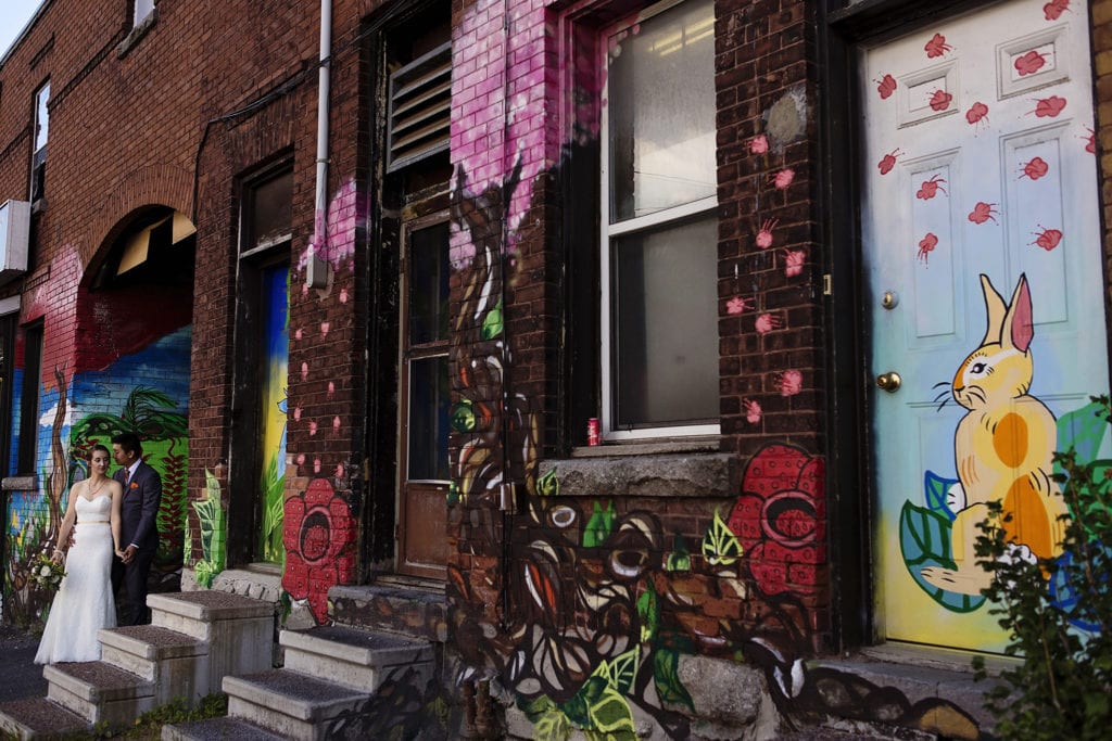 bride and groom cuddle along length of Ottawa Chinatown doorway graffiti featuring rabbits