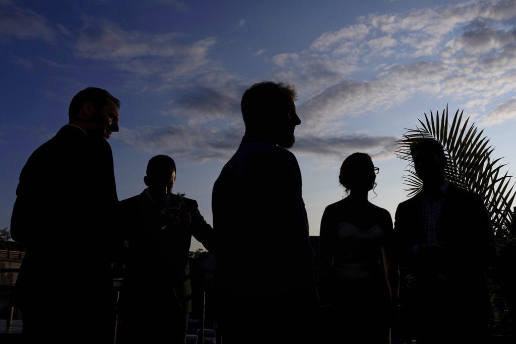 wedding guests in silhouette against blue sky during Orange Art Gallery wedding reception