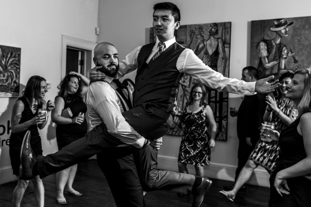 one man holds other man in the air in his arms on dance floor