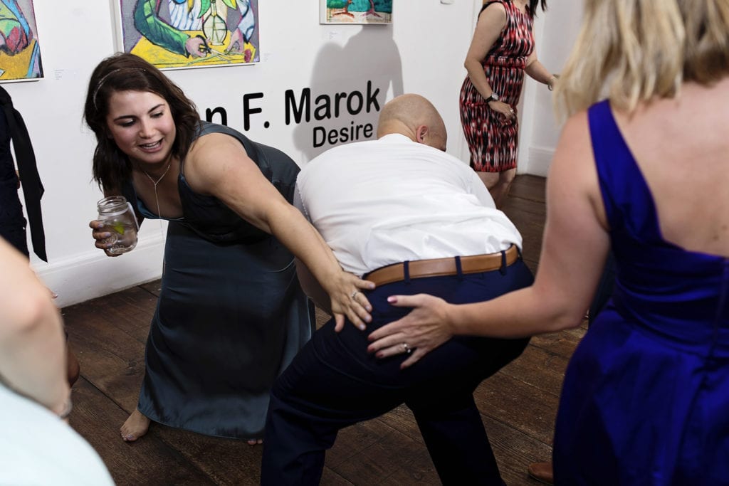 woman slap man's backside as he dances