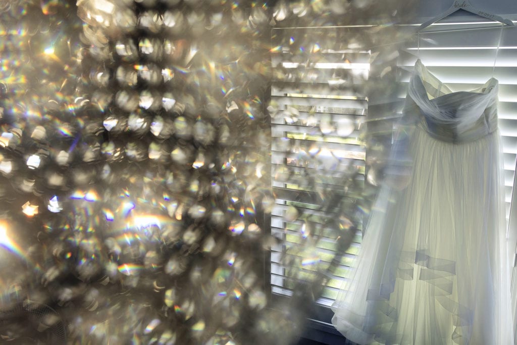 wedding dress hangs in window