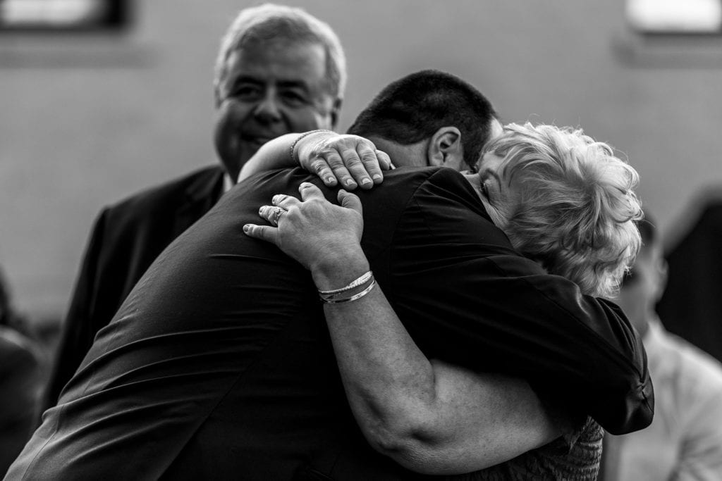 groom hugs mother at start of wedding ceremony