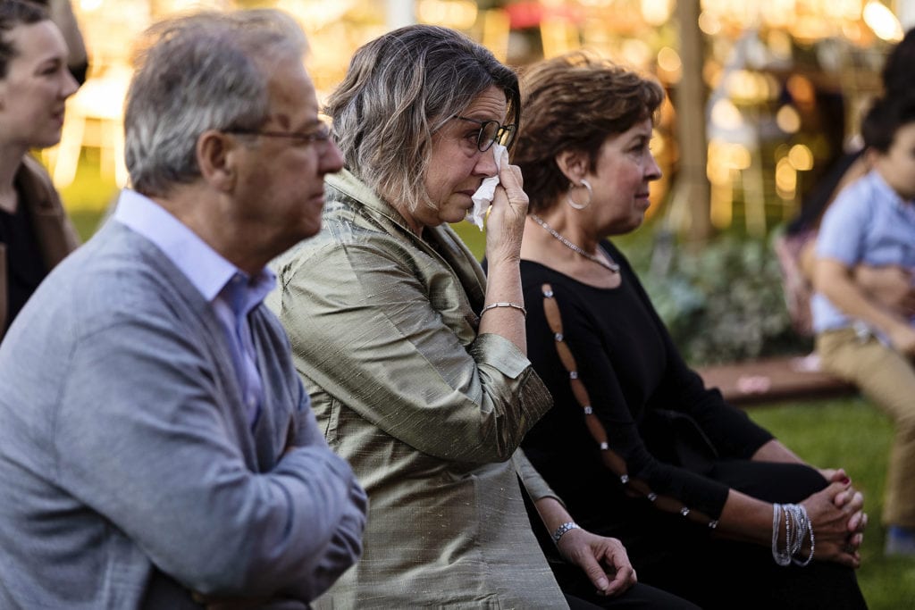 wedding guests dabs tears from eyes during ceremony