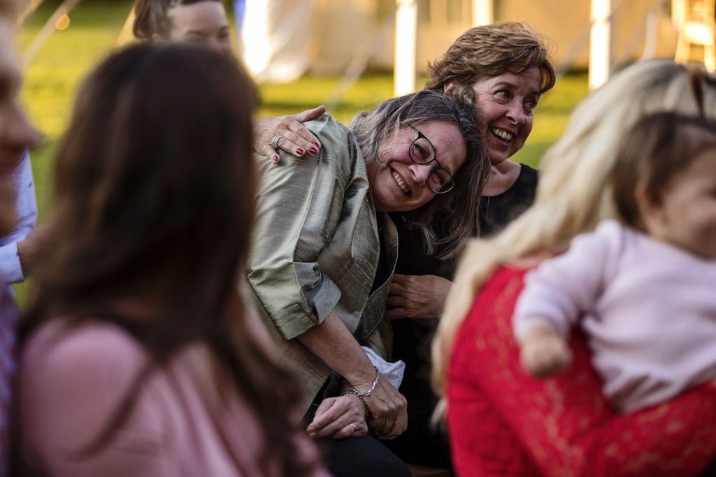 wedding guests pulls woman close during ceremony