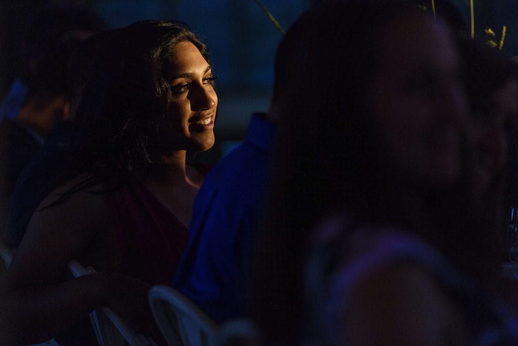 wedding guests listens to speeches while being lit by sun