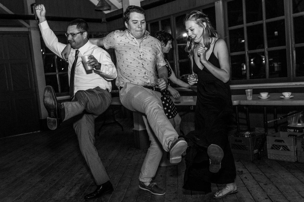 three people dance and kick feet up