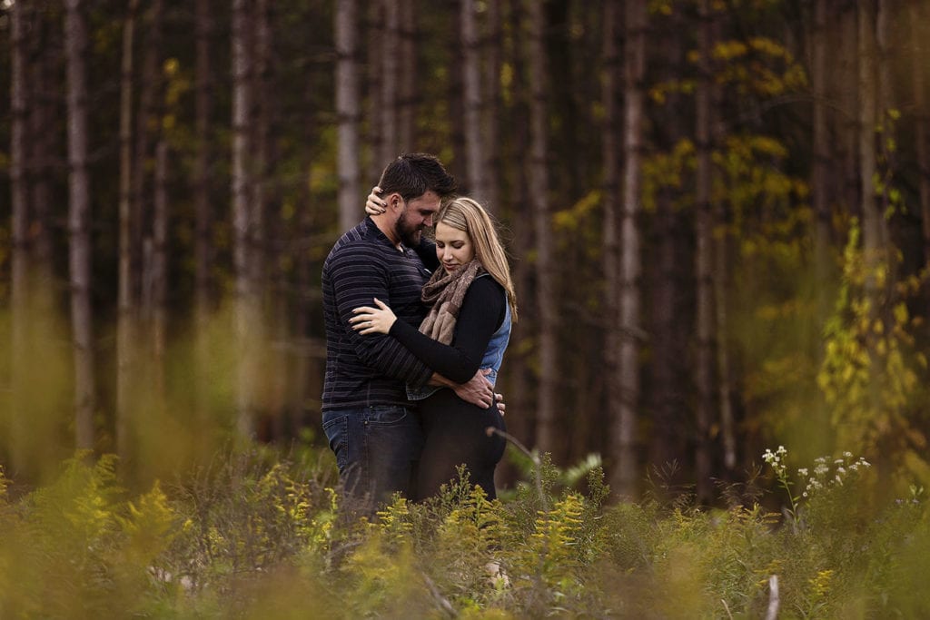 romantic young couple in forest during woodsy engagement shoot