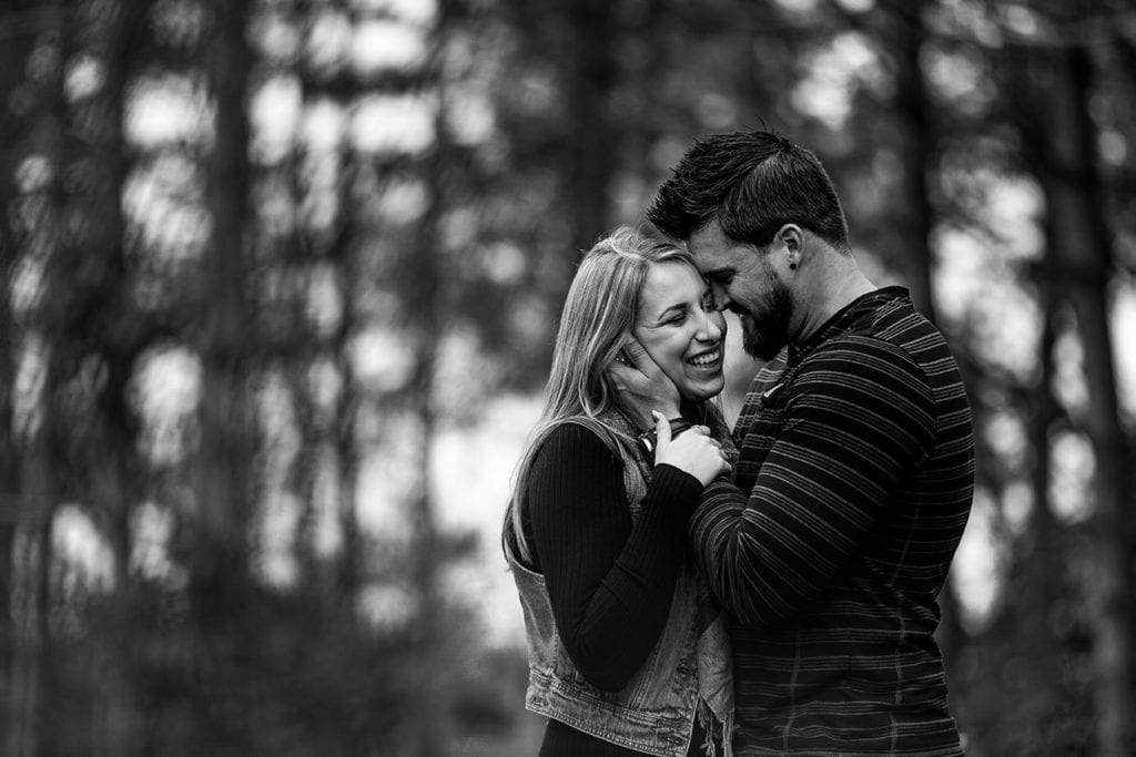 couple laughing in fall woodsy engagement shoot