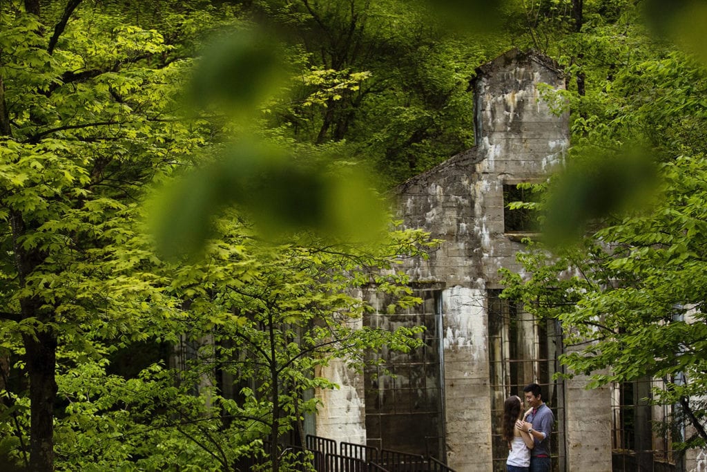couple smiling and embracing at Gatineau Park ruins during summer engagement session