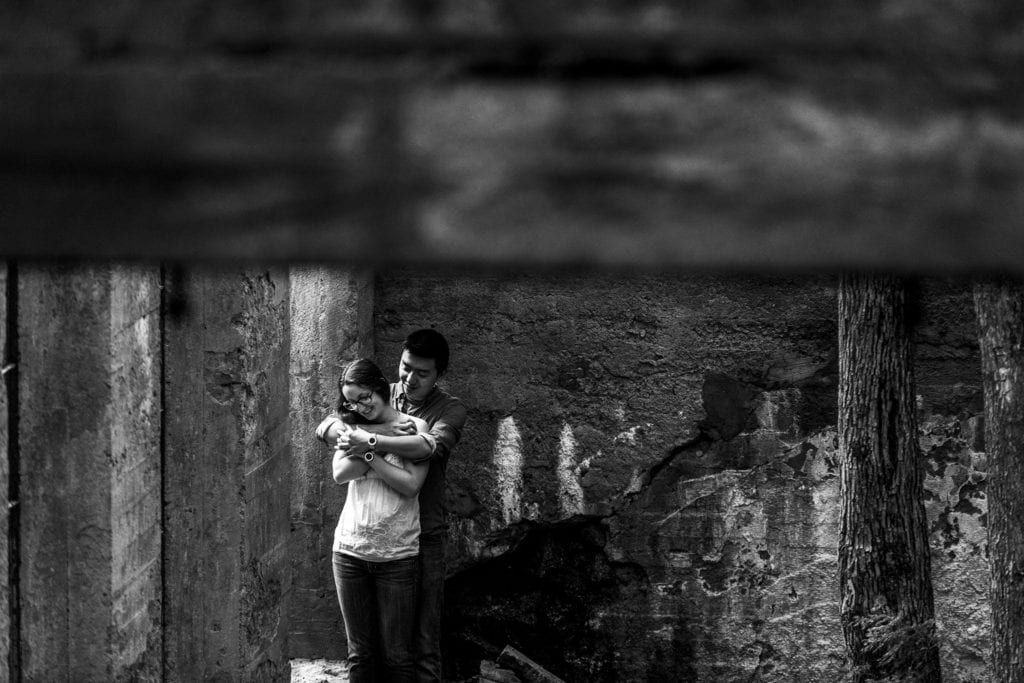 couple embracing in Gatineau Park ruins during summer engagement session