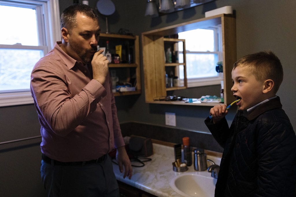 dad and son brush teeth together in preparation for Adoption day in Cornwall