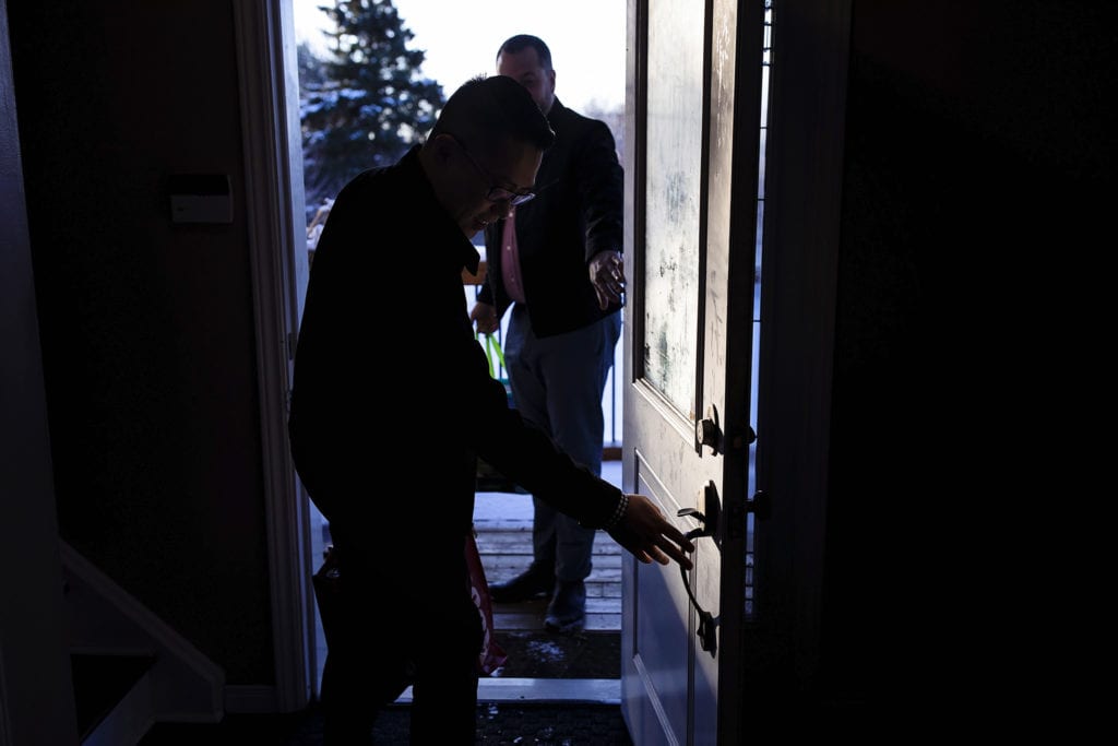 men leaving house through front door on way to Adoption day in Cornwall