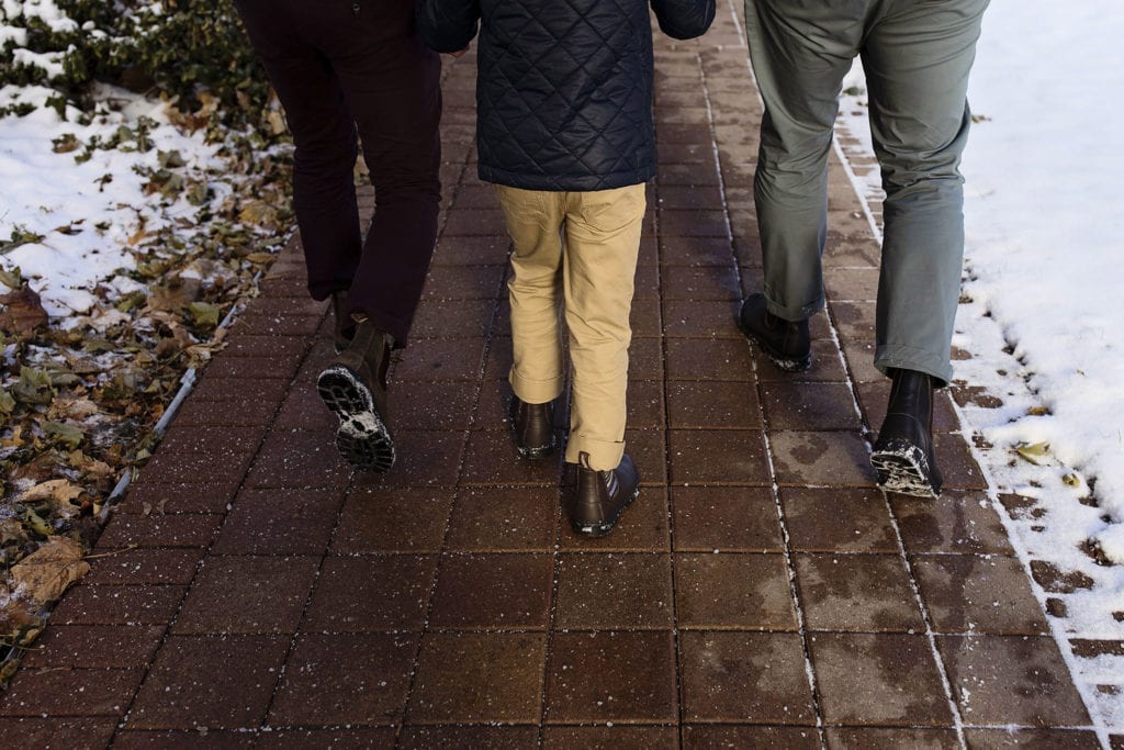dads and son walk the sidewalk towards courthouse on Adoption day in Cornwall